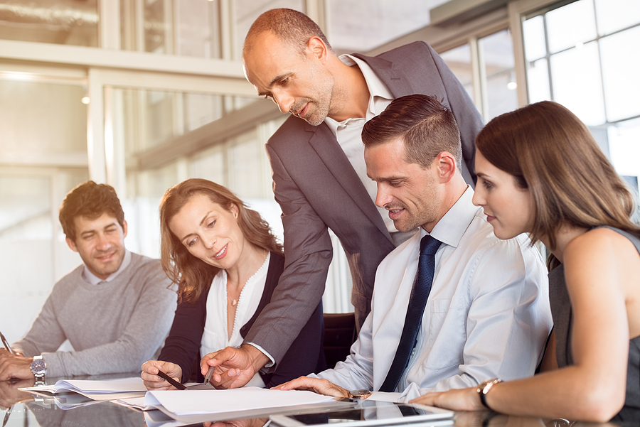 Team leader pointing at report during meeting with his colleague Real estate listing marketing